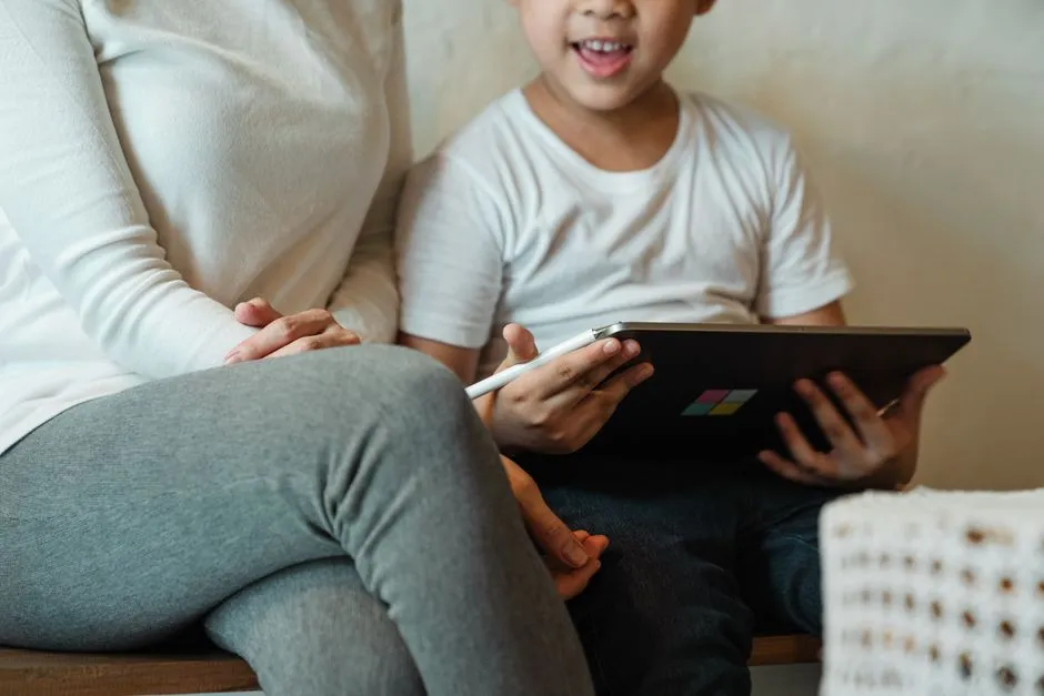 Parent and child sitting together looking at a tablet screen at home